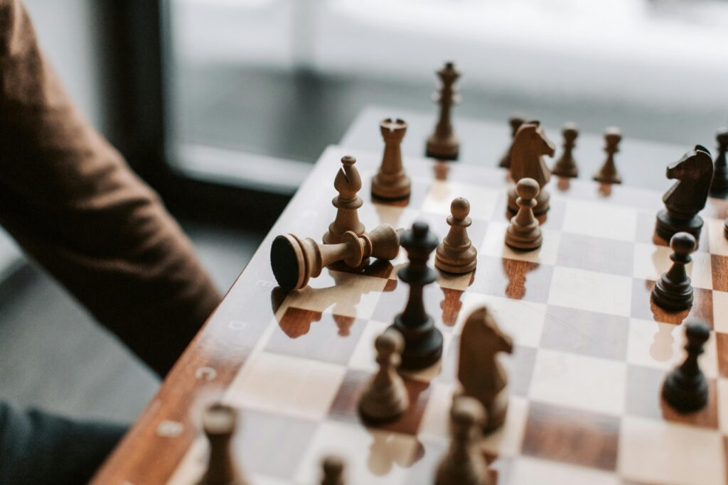 Close-up of a chessboard highlighting a pivotal moment with the king tipped over.